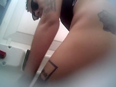 Beautiful inked rookie pees in a public toilet