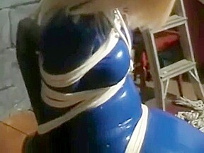 Bev ballgagged and tied with ropes to chair