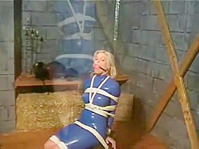 Bev ballgagged and tied with ropes to chair