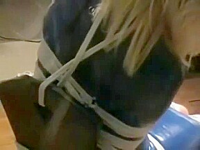 Bev ballgagged and tied with ropes to chair
