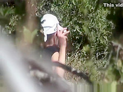 Blonde woman in shorts caught peeing in the nature