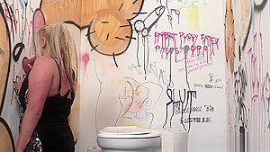 Busty british babe sucking at the gloryhole