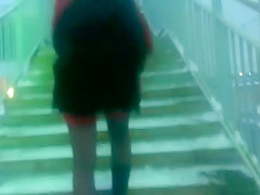 Chick flashing her black stockings with the red tops outdoor