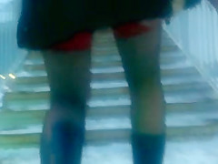 Chick flashing her black stockings with the red tops outdoor