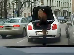 Girl changing shoes in miniskirt on street
