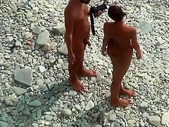 Girl with plug in the ass poses for a guy at public beach 2