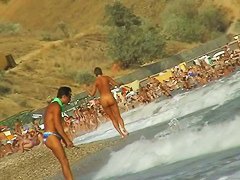 Lush bodied MILF parades before a nude beach