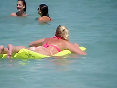 Pale buttocks in a pink thong bikini