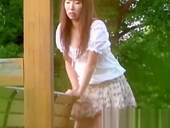 Tantalizing Japanese in skirt peeing behind bench in park