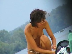 Topless sleek hotties on the nude beach getting filmed by a