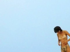 Topless sleek hotties on the nude beach getting filmed by a