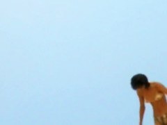 Topless sleek hotties on the nude beach getting filmed by a