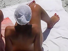 Women gives handjob to her man till he cums at the beach